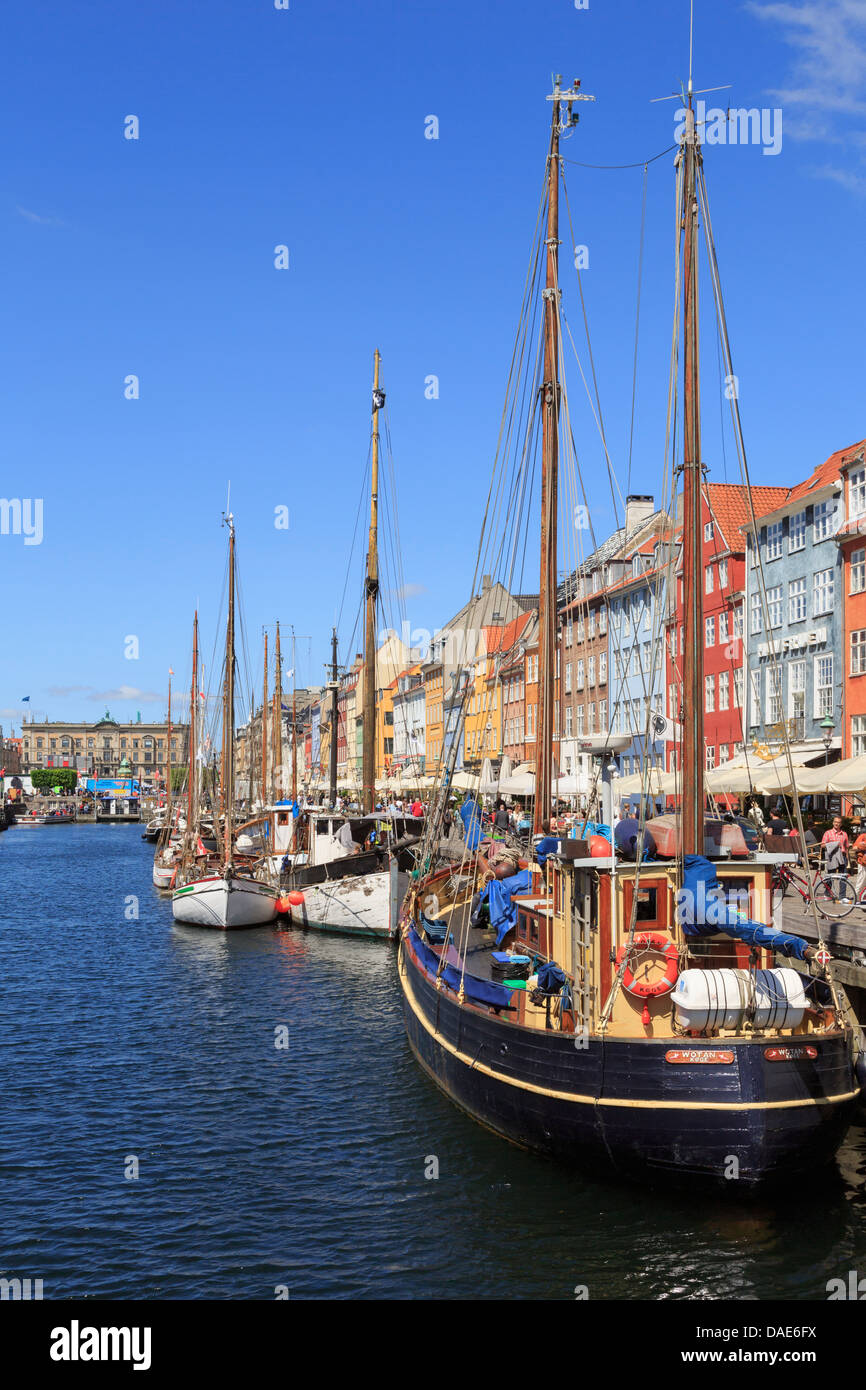 Vecchie barche di legno ormeggiate sul canale con edifici sul lungomare nel porto di Nyhavn, Copenaghen, Zelanda, Danimarca, Scandinavia, Europa Foto Stock