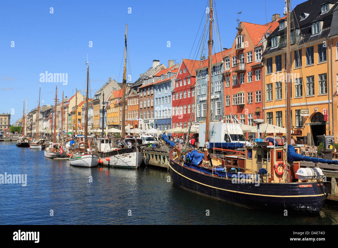 Vecchie barche di legno ormeggiate sul canal con colorati del XVII secolo gli edifici sul lungomare nel porto di Nyhavn a Copenaghen Zelanda Danimarca Foto Stock