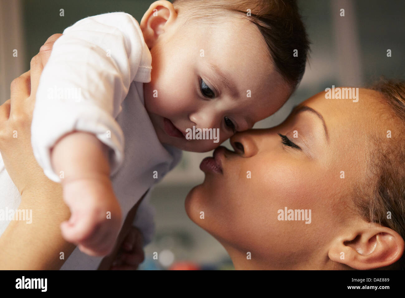Madre kissing Baby girl sua guancia Foto Stock