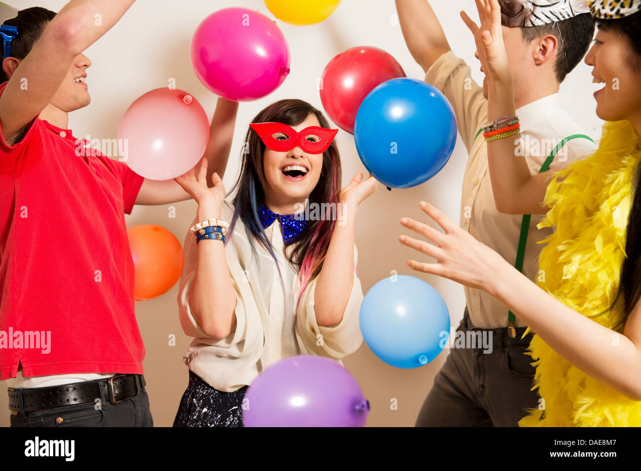 Gli amici a una festa con palloncini, studio shot Foto Stock