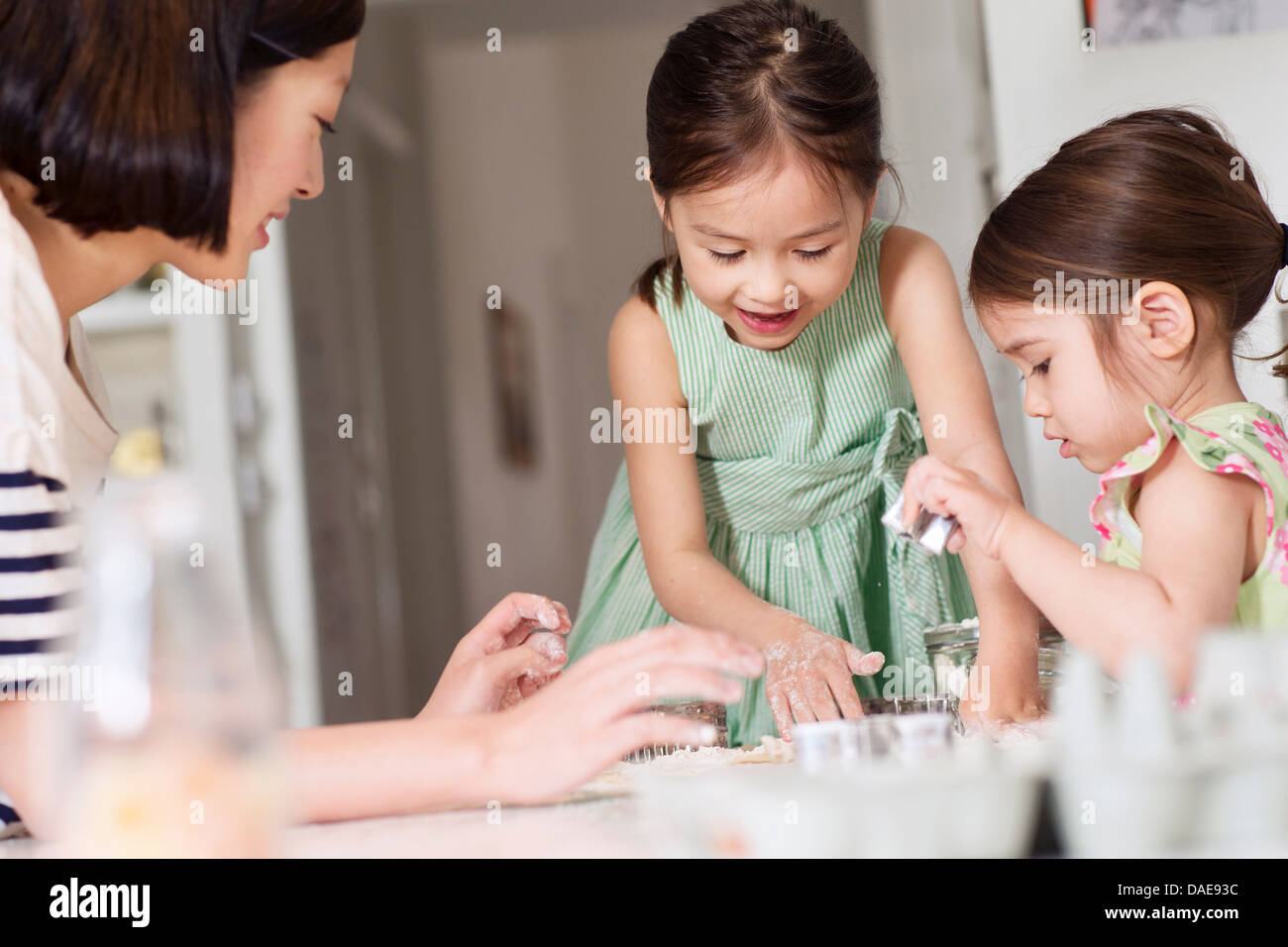 Madre e giovani figlie rendendo la pasticceria Foto Stock