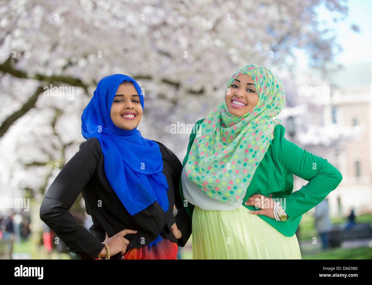 Ritratto di due giovani femmine nel parco con le mani sui fianchi Foto Stock