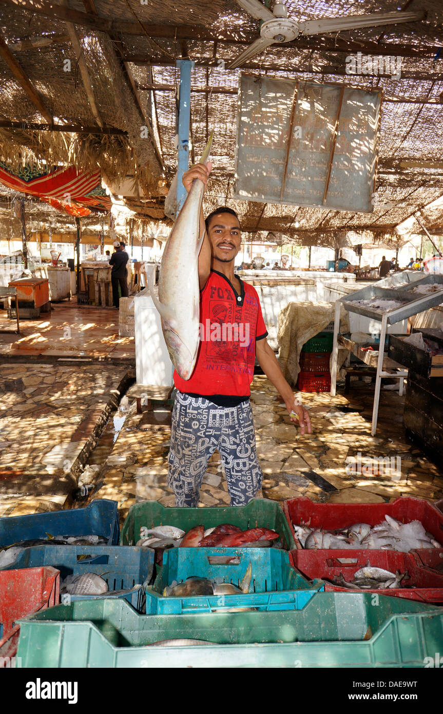 Fish monger presso il mercato del pesce è orgogliosa di presentare un pesce, Egitto, Hurghada Foto Stock