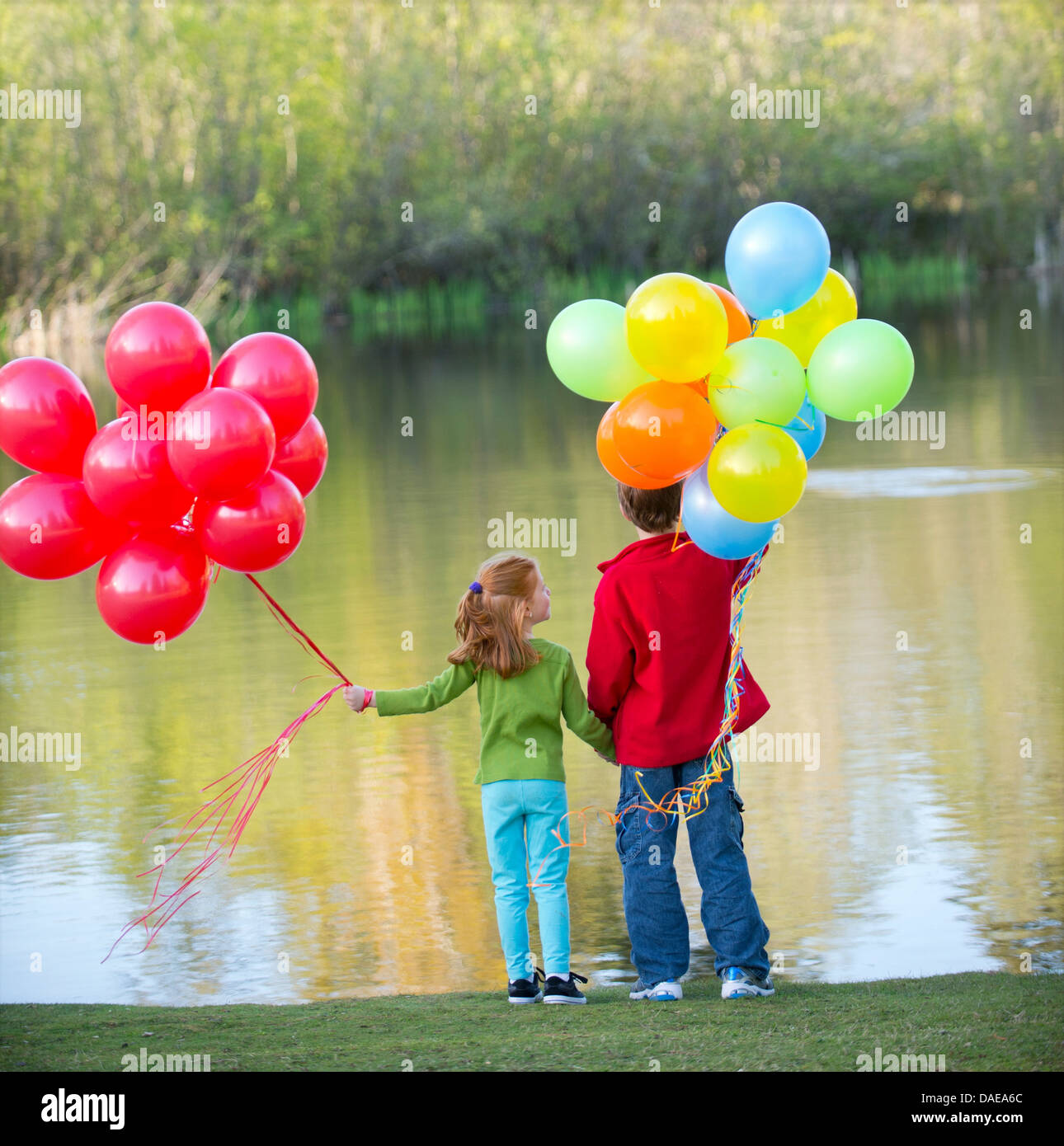Fratello e Sorella di palloncini di contenimento in posizione di parcheggio Foto Stock