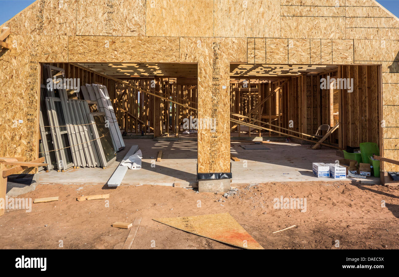 Nuova casa cuconstruction nelle zone rurali di Oklahoma, Stati Uniti d'America che mostra il doppio garage auto con una pila di nuovo windows appoggiato contro una parete. Foto Stock