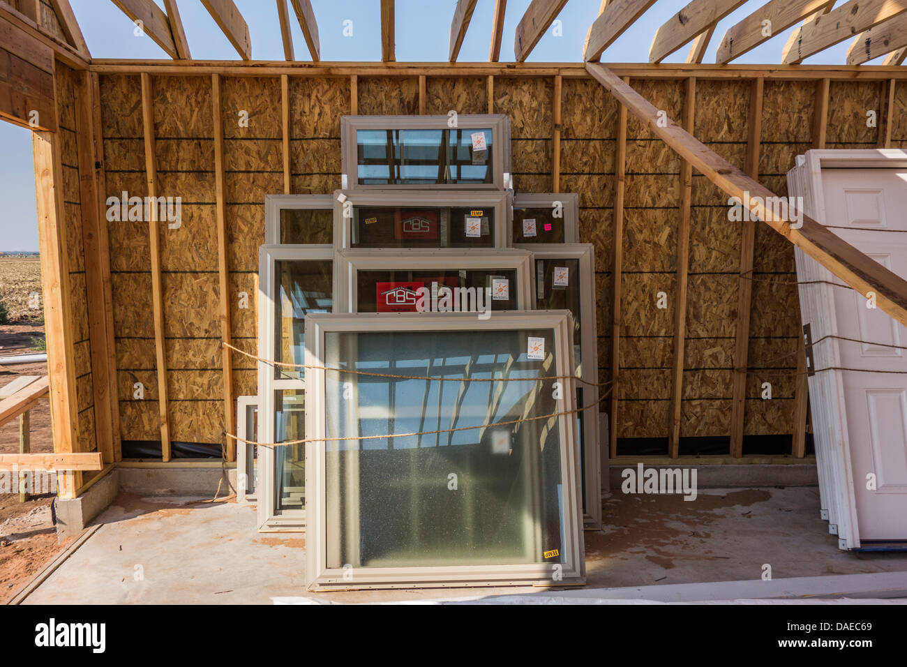 Casa nuova costruzione personalizzata in rurale Oklahoma, Stati Uniti d'America, che mostra una pila di nuovo Windows nel garage area. Foto Stock