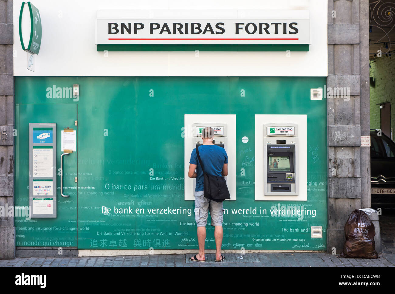 L'uomo la raccolta di denaro a cash dispenser della BNP Paribas Fortis Bank, Belgio Foto Stock
