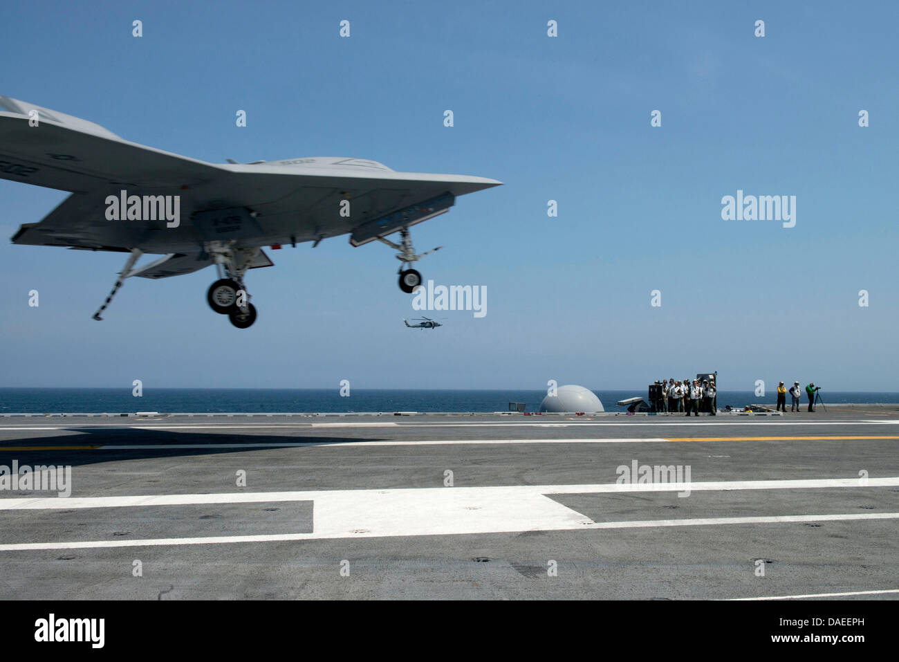 Un US Navy X-47B Unmanned Combat Air System drone arriva a terra sul ponte di volo della portaerei USS George H.W. Bush Luglio 10, 2013 operanti nell'Oceano Atlantico. Lo sbarco ha segnato la prima volta che un velivolo senza equipaggio completato un arrestato in atterraggio a mare. Foto Stock