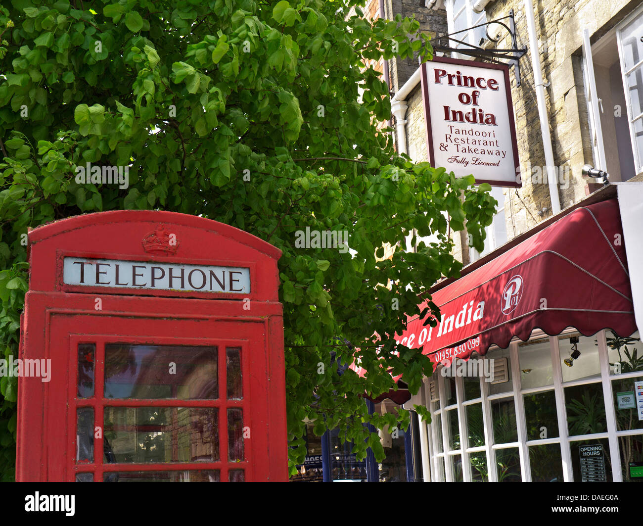 British tradizionale rosso nella casella Telefono al di fuori di un tipico Indian Curry House Inghilterra REGNO UNITO Foto Stock