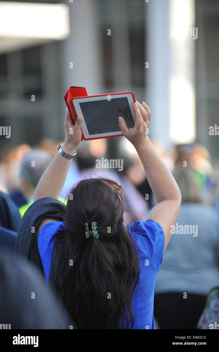 Il London Bridge e il coccio, Londra, Regno Unito. 11 luglio 2013. Una donna con un iPad prende le fotografie alla base del Shard, come i manifestanti di Greenpeace salire verso l'alto. Credito: Matteo Chattle/Alamy Live News Foto Stock
