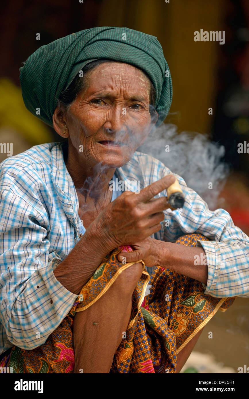 Il vecchio donna seduta sul mercato fumatori, Birmania, Bagan Foto Stock