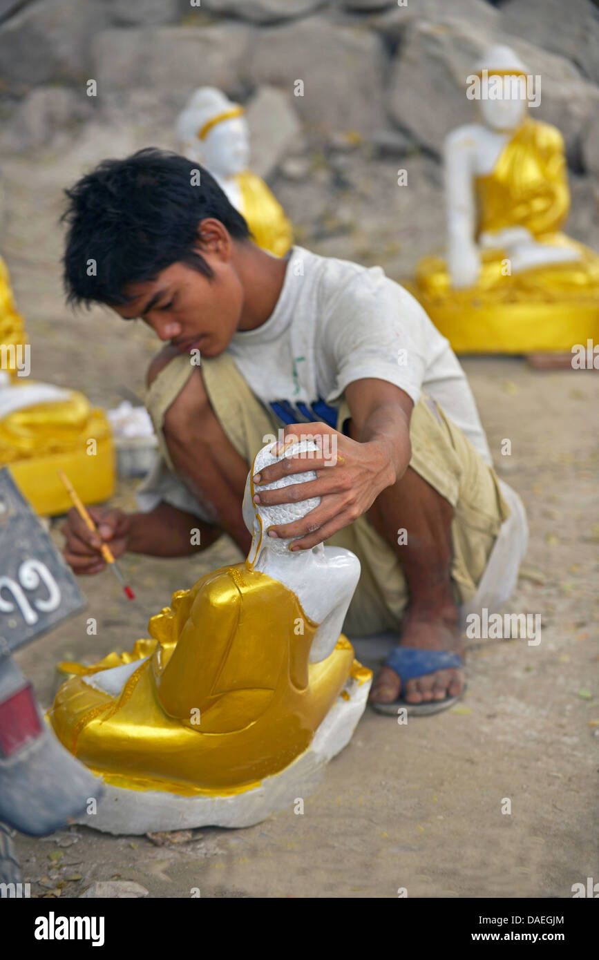 Giovane uomo che fa un Buddha d'oro di scultura, Birmania, Mandalay Foto Stock