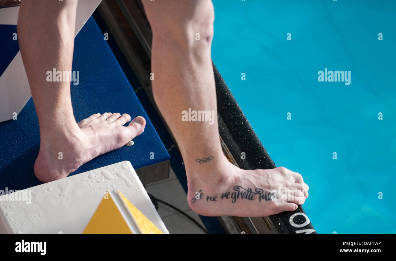 Il tatuato frase "Je ne regrette rien" (non mi dispiace nulla) mostra sul piede del nuotatore tedesco Marco Di Carli durante la breve distanza nuoto campionati a Wuppertal, Germania, 25 novembre 2011. Foto: Bernd Thissen Foto Stock