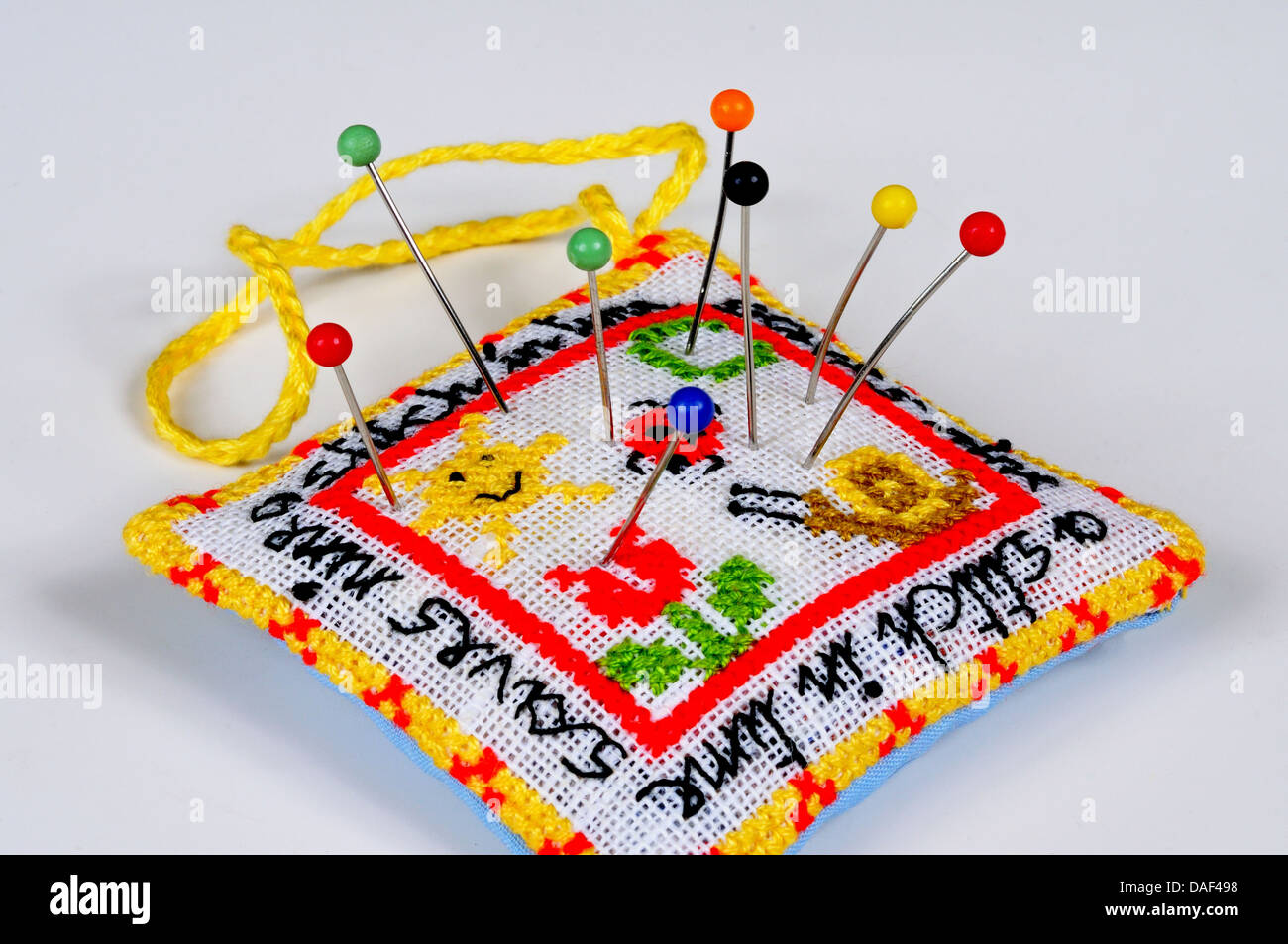 A Stitch in Time salva nove puntaspilli con perni contro uno sfondo semplice. Foto Stock