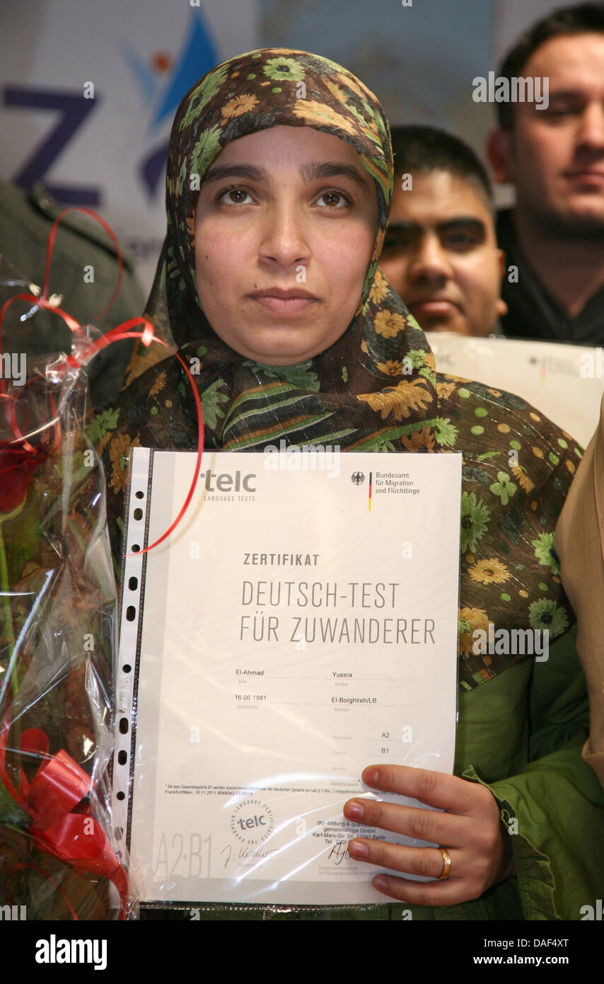 Yussra El Ahmad dal Libano (R) mantiene il suo 'Test di tedesco per immigrati' certificato al dtz Education Center a Berlino, Germania, 02 dicembre 2011. I certificati di integrazione sono stati assegnati a 20 persone dopo aver superato il tedesco-B1-test. Foto: Stephanie Pilick Foto Stock