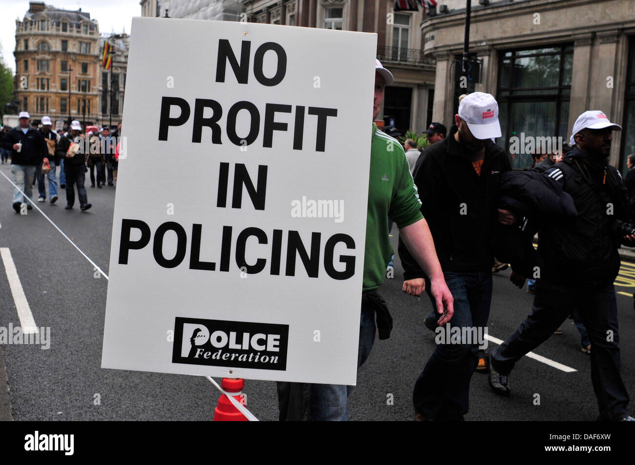 Un dovere funzionario di polizia con un banner di lettura ' no profit in operazioni di polizia", London, Regno Unito Foto Stock