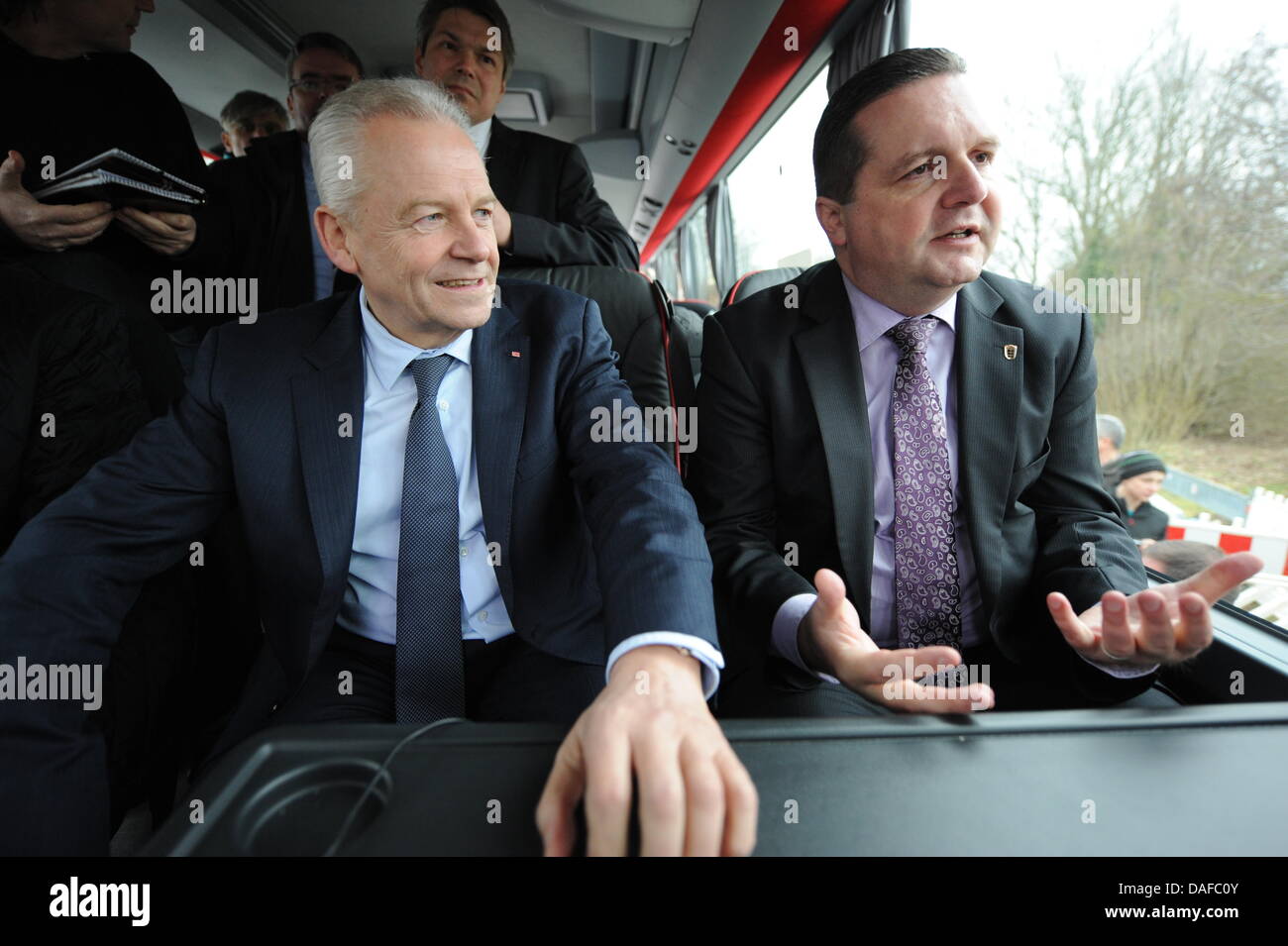 Il Presidente delle Ferrovie Tedesche, Ruediger Grube (L), e il Baden-Württemberg del ministro presidente (CDU, R) rispondere alle domande del giornalista in un bus in Buggingen, Germania, 18 febbraio 2011. Mappus e Grube si è incontrato con gli avversari di espansione del Mannheim-Karlsruhe-stazione ferroviaria di Basilea. Foto: Patrick Seeger Foto Stock