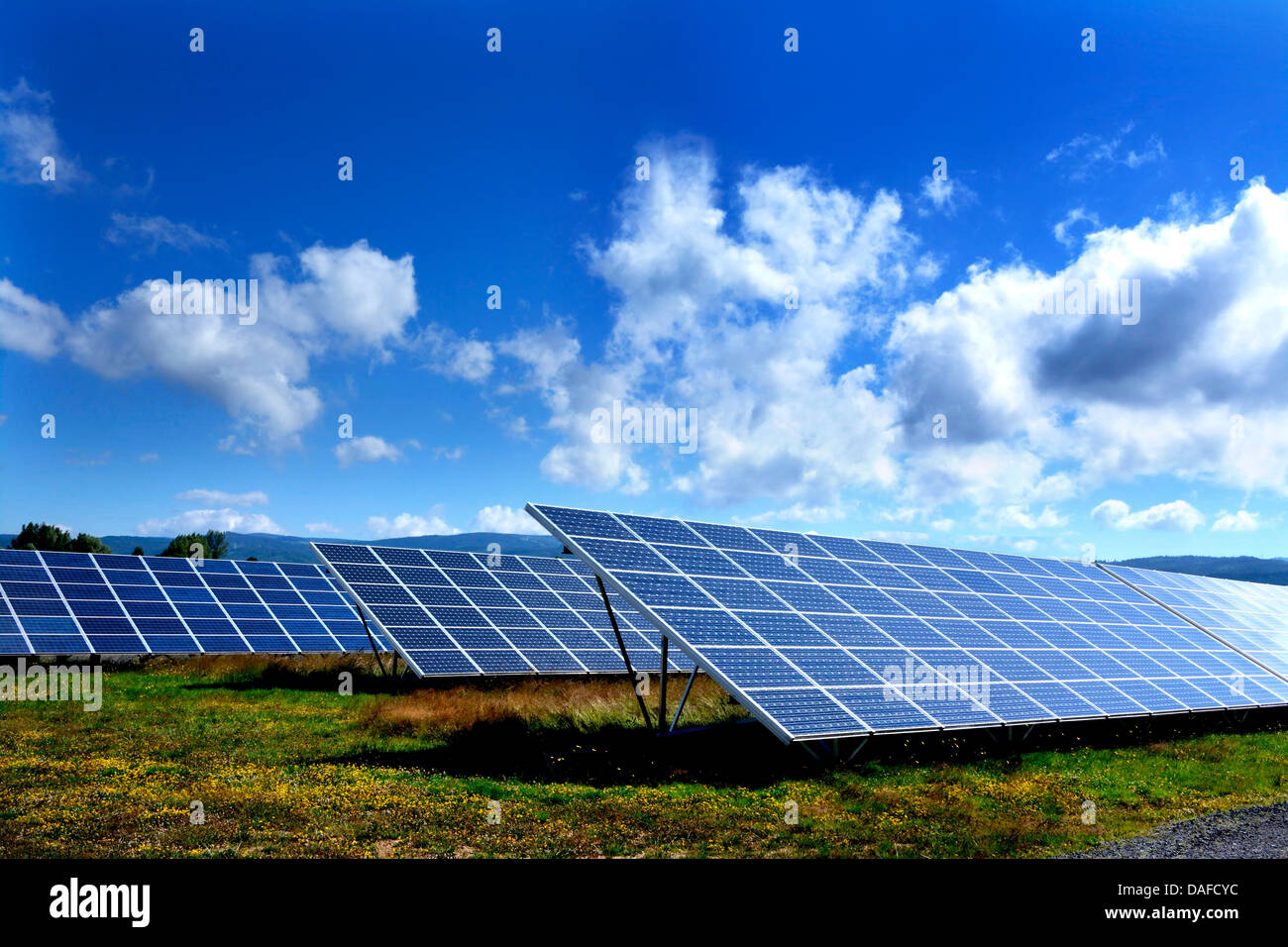 I pannelli solari producono energia rinnovabile in un array di grandi dimensioni a un impianto fotovoltaico. Auvergne. Francia Foto Stock