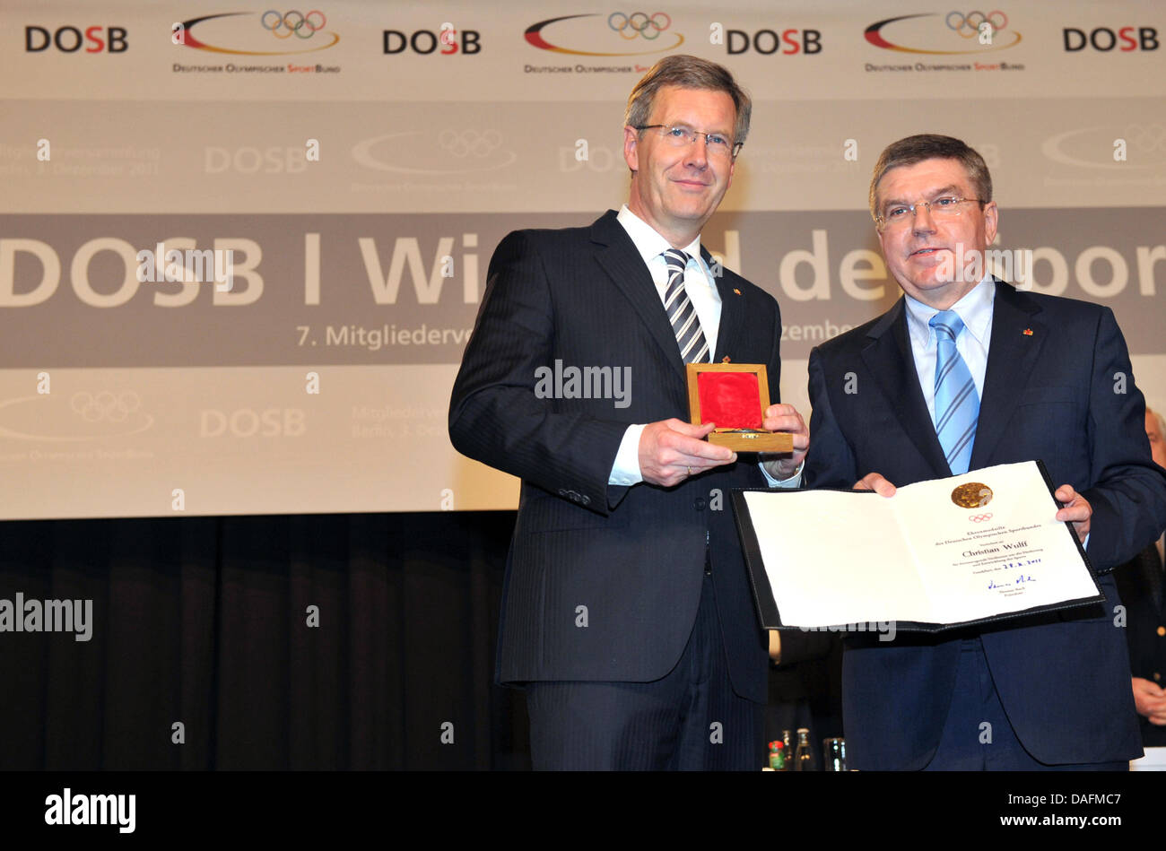 Il Presidente tedesco Christian Wulff (L) riceve la medaglia d'onore della tedesca sport olimpici Confederazione (DOSB) dal DOSB il presidente Thomas Bach a Berlino, Germania, 03 dicembre 2011. In seguito Wolfgang Schaeuble, Horst Koehler e Richard von Weizsaecker, Wulff è il quarto uomo politico a ricevere questo onore per il suo continuo impegno nella promozione dello sport in Ger Foto Stock