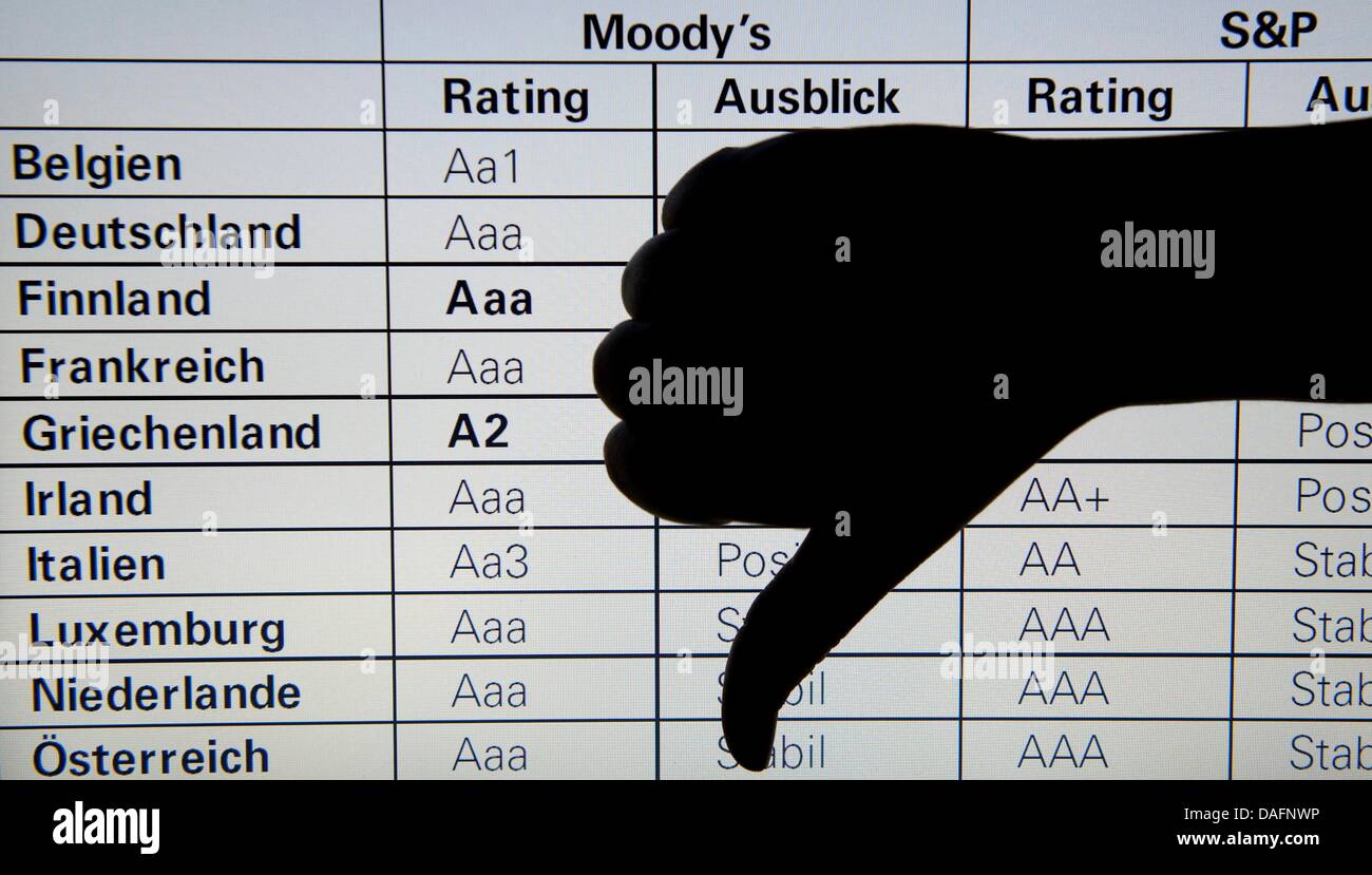 Illustrazione - La figura mostra una mano gesticolando un pollice in giù nella parte anteriore di un sito web che mostra una tabella con le valutazioni della politica europea di titoli di stato a Berlino, Germania. Agenzia di rating Standard & Poor ha minacciato di declassare il rating del credito della zona euro. Foto: Sebastian Kahnert Foto Stock