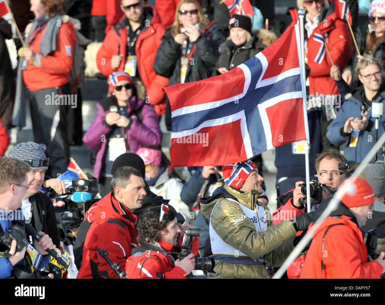 Medaglia d'oro Petter Northug della Norvegia è seguita da fotografi sul suo modo attraverso lo stadio dopo la Sci di fondo maschile 50 km di sci nordico ai Campionati Mondiali di Oslo, Norvegia, 06 marzo 2011. Foto: Hendrik Schmidt dpa Foto Stock