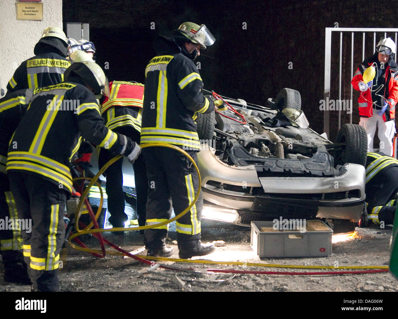 Ispezionare i vigili del fuoco di una vettura che è caduto un parcheggio multipiano a Bonn, Germania, 07 marzo 2011. La vettura è scesa a dodici metri giù, il 19-anno-vecchio pasenger e 16-anno-vecchio driver sono stati uccisi. Foto: Barbara FOMMANN Foto Stock