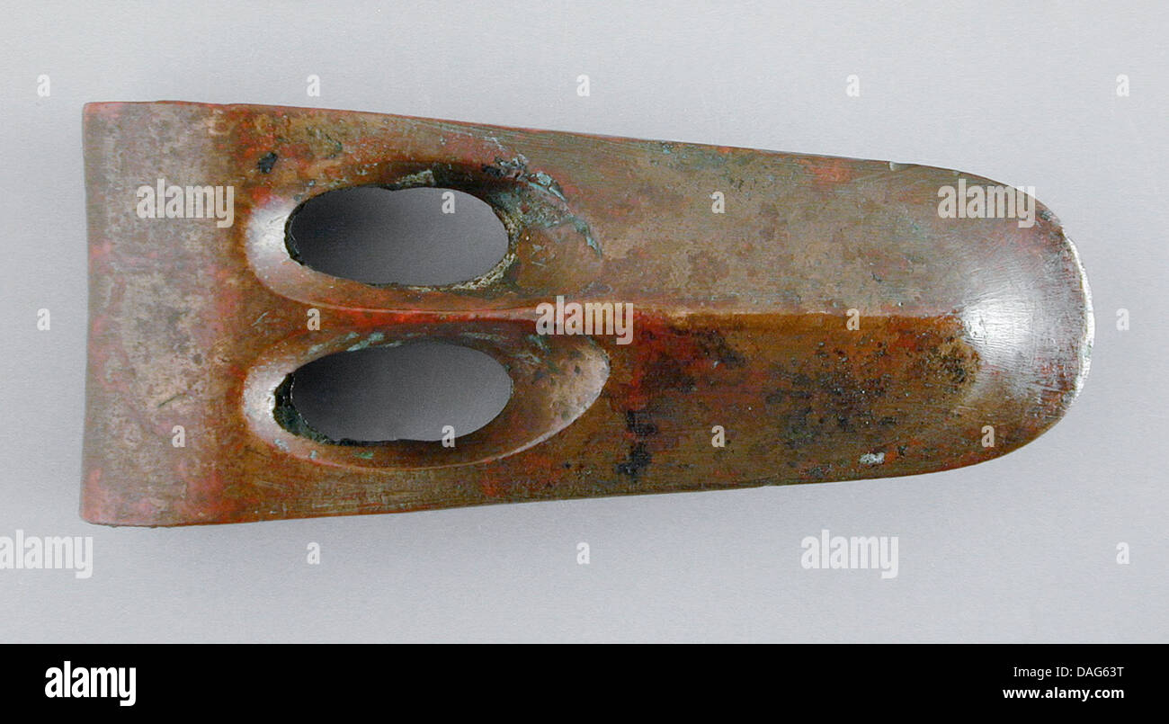 Questa ascia proto-fenicia è un antico strumento che mostra le prime fasi della lavorazione dei metalli fenicia. Il design dell'asse riflette l'importanza funzionale e culturale di tali strumenti nelle prime società mediterranee. Foto Stock