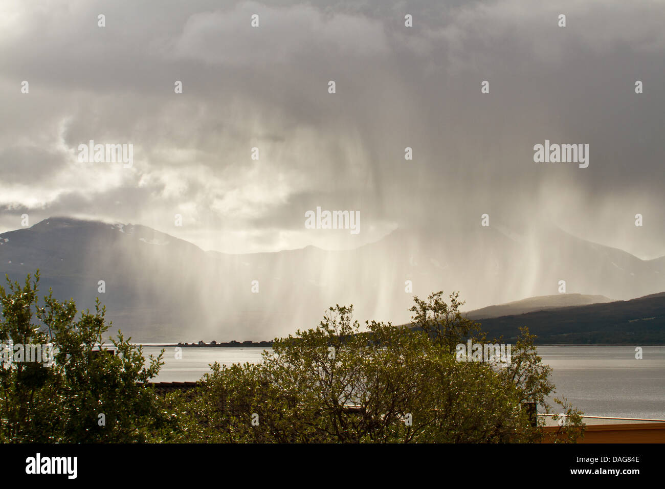 Doccia a pioggia su Sandnes suono in controluce, Norvegia, Troms, Tromsoe, Sandnessund Foto Stock