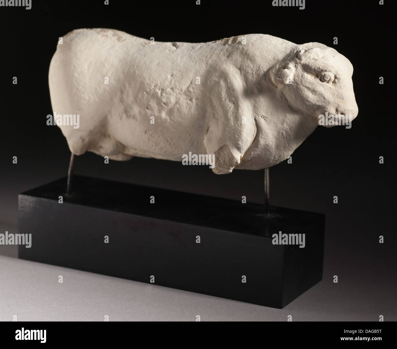 Questa figura in ceramica bianca rappresenta un toro, probabilmente prodotto in tempi antichi, che riflette il significato degli animali nelle prime culture. Il toro, spesso simboleggia la forza o la fertilità, è raffigurato in una forma stilizzata. Foto Stock