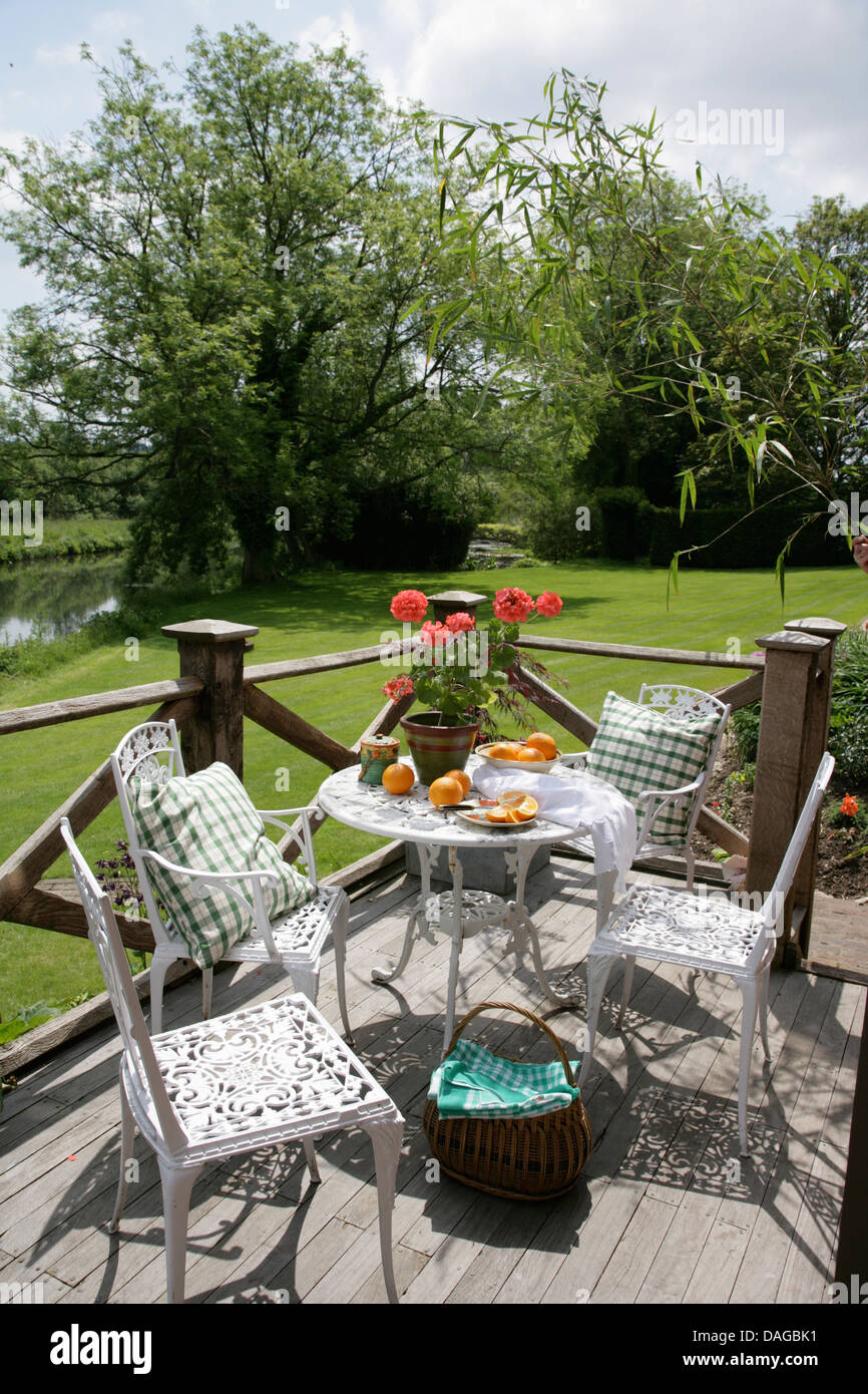 Letti in ferro battuto con tavolo e sedie verde con cuscini controllato sul  balcone arredato che si affaccia su prato in country garden Foto stock -  Alamy