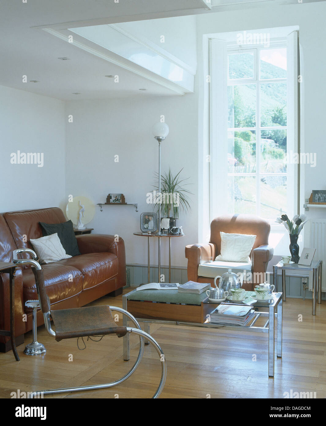 Chrome anni trenta poltrona e divani in pelle marrone e pavimenti in legno  in soggiorno moderno in cappella convertito Foto stock - Alamy