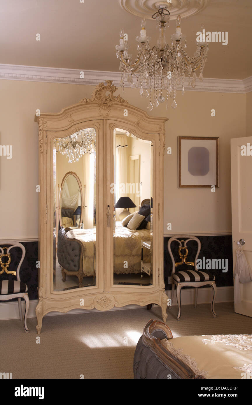 Striped sedie rivestite su entrambi i lati dello stile francese armadio con  porte a specchio in camera da letto opulenta con lampadario in vetro Foto  stock - Alamy