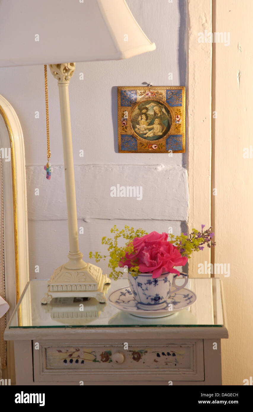 Close-up di bianco lampada di metallo e di vetro sovrastata comodino con rosa rosa in blu+bianco coppa di cina Foto Stock
