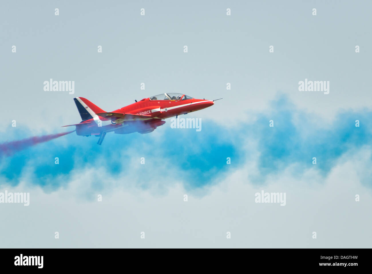 Un British Royal Air Force frecce rosse Hawk Jet Trainer passa attraverso il vapore di blu di uno dei membri del team jet come essi display. Foto Stock