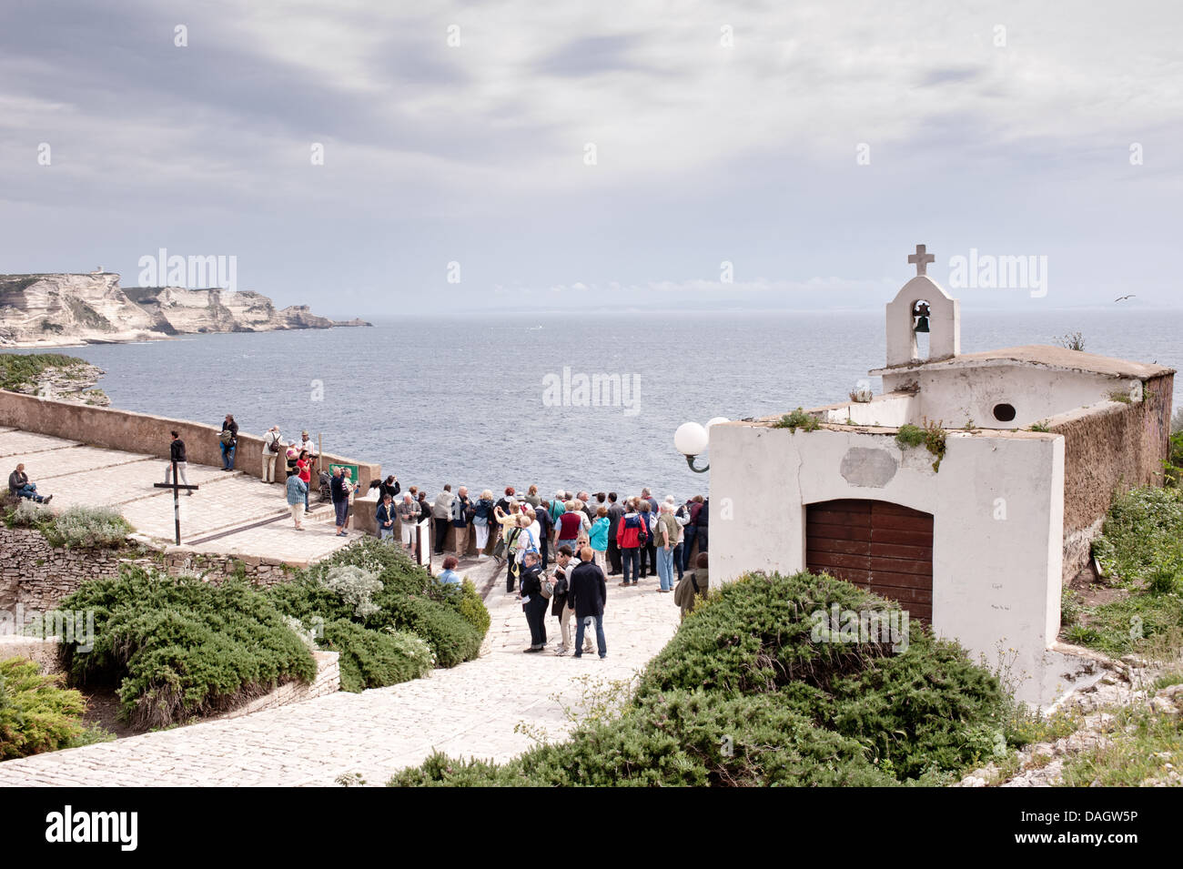 Bonifacio, Corsica, Francia - turista a godere la vista sulle Bocche di Bonifacio da scogliere. Foto Stock