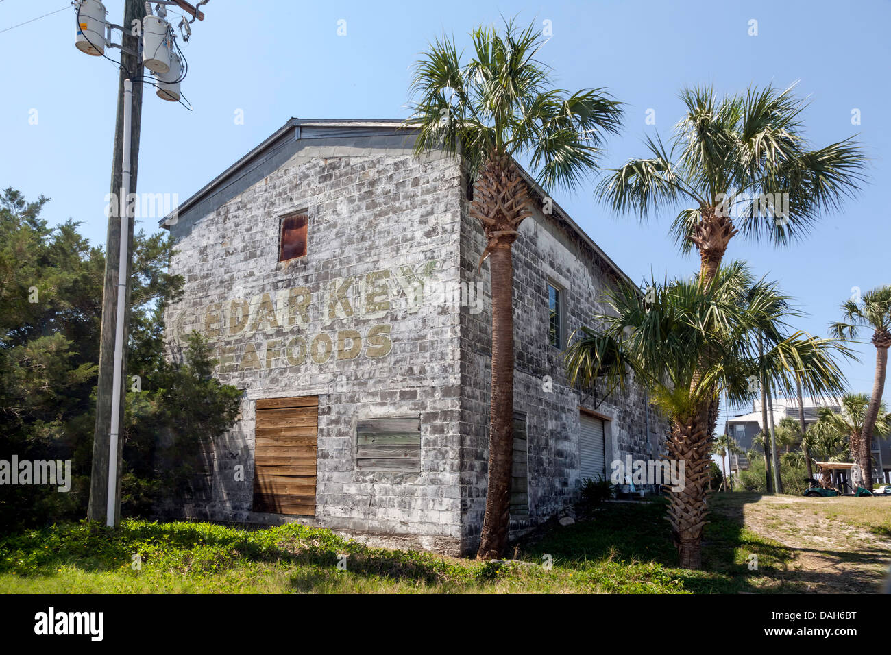 Saliti fino, chiuse e abbandonate Cedar Key Seafood edificio con pareti scrostate e sbiadite segno dipinto. Foto Stock