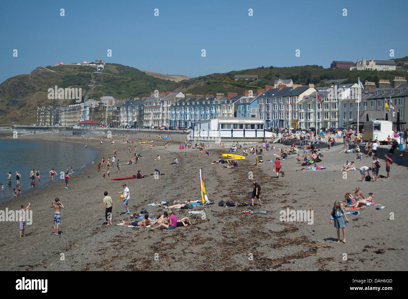 Aberystwyth, Wales, Regno Unito. 13 luglio 2013. La gente del posto e turisti godere della canicola estiva a nuoto in mare e ottenere una abbronzatura sulla spiaggia presso la località balneare di Aberystwyth. Come temperature attraverso il Regno Unito raggiunge 30 gradi Celsius, si tratta di una giornata di mare piatto, cielo sereno, gelati e creme solari come la popolazione di Aberystwyth crogiolarsi nella gloriosa Meteo weekend. Credito: Barry Watkins/Alamy Live News Foto Stock