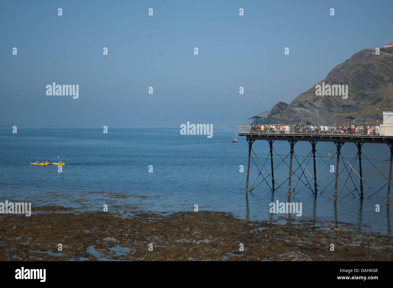 Aberystwyth, Wales, Regno Unito. 13 luglio 2013. Le persone che si godono le estati calde giorno in Aberystwyth, sia esso avente una bevanda fredda sul molo, o kayak sul piatto e limpido mare di Cardigan Bay. Credito: Barry Watkins/Alamy Live News Foto Stock