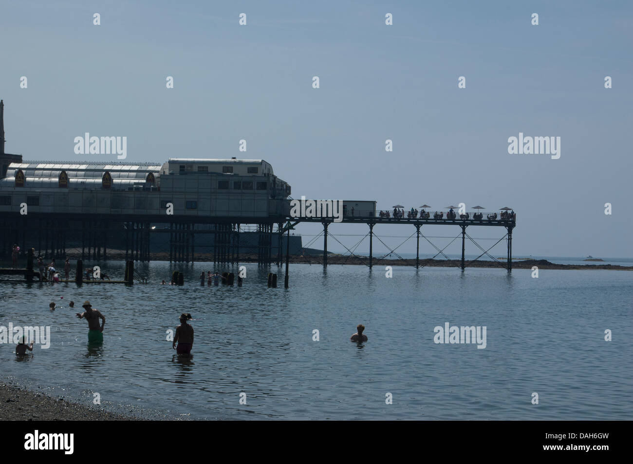 Aberystwyth, Wales, Regno Unito. 13 luglio 2013. La gente del posto e turisti godere della canicola estiva a nuoto in mare e ottenere una abbronzatura sulla spiaggia presso la località balneare di Aberystwyth. Come temperature attraverso il Regno Unito raggiunge 30 gradi Celsius, si tratta di una giornata di mare piatto, cielo sereno, gelati e creme solari come la popolazione di Aberystwyth crogiolarsi nella gloriosa Meteo weekend. Credito: Barry Watkins/Alamy Live News Foto Stock