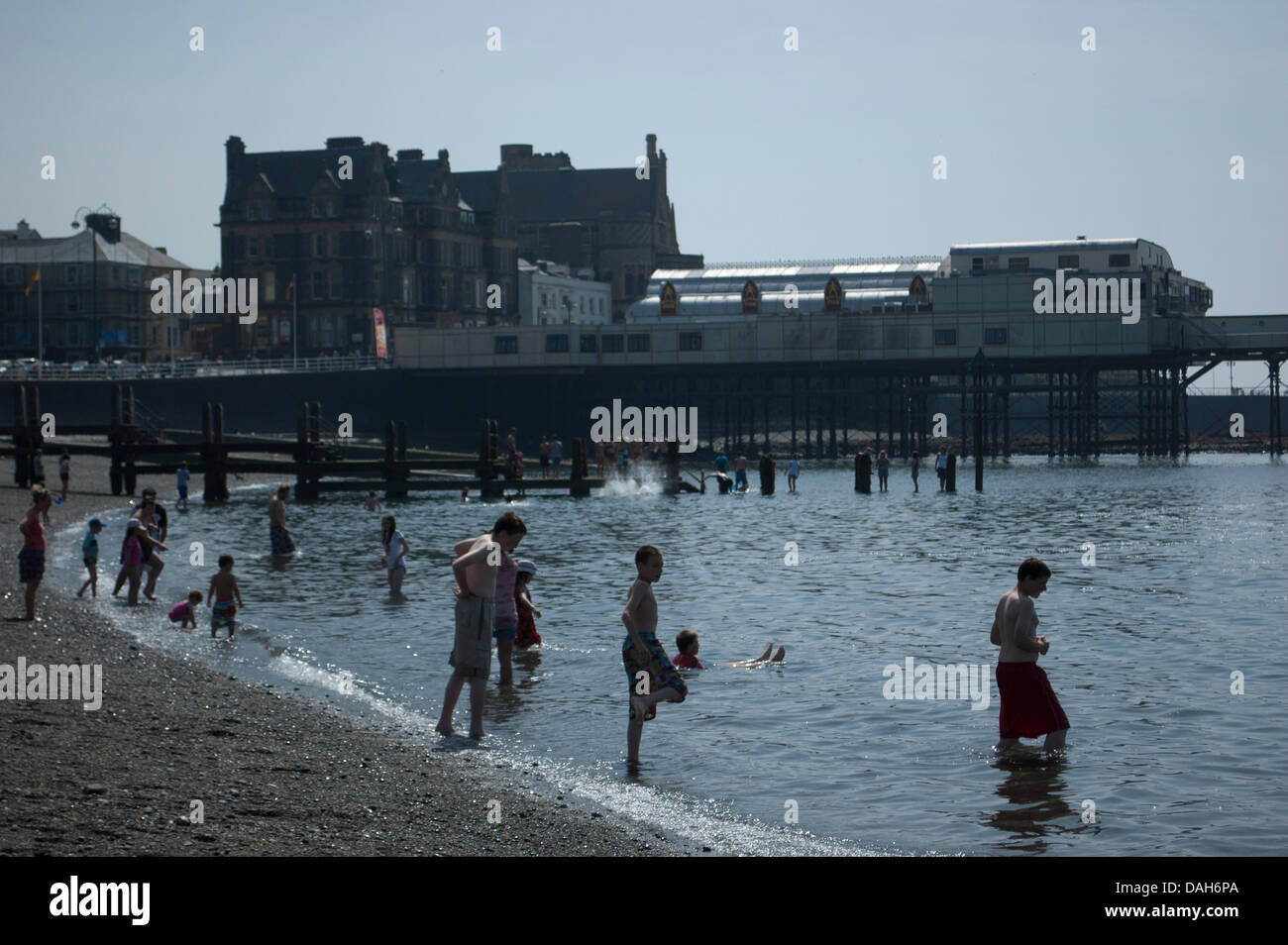 Aberystwyth, Wales, Regno Unito. 13 luglio 2013. La gente del posto e turisti godere della canicola estiva a nuoto in mare e ottenere una abbronzatura sulla spiaggia presso la località balneare di Aberystwyth. Come temperature attraverso il Regno Unito raggiunge 30 gradi Celsius, si tratta di una giornata di mare piatto, cielo sereno, gelati e creme solari come la popolazione di Aberystwyth crogiolarsi nella gloriosa Meteo weekend. Foto Stock