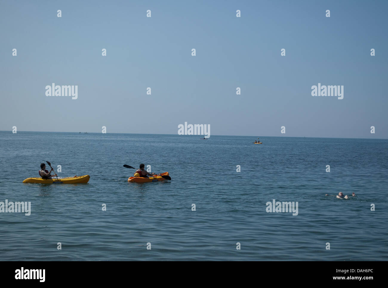 Aberystwyth, Wales, Regno Unito. 13 luglio 2013. Un nuotatore e kayakers approfittare del clima caldo e mare piatto a Aberystwyth, in un giorno quando le temperature sono impostati per raggiungere 30 gradi Celsius in tutto il Regno Unito. Credito: Barry Watkins/Alamy Live News Foto Stock