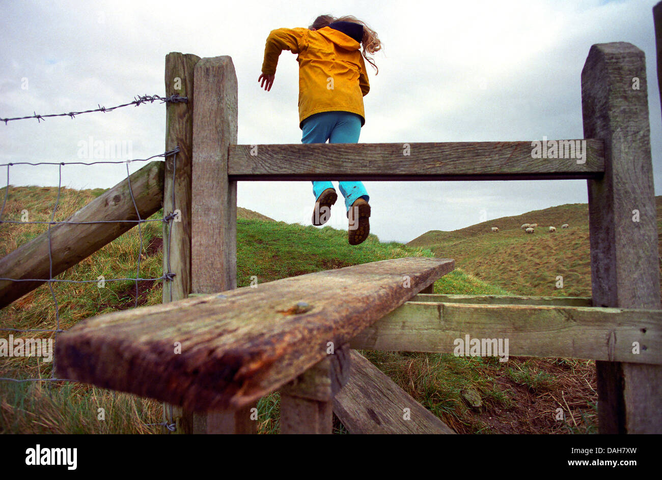 Bambino che salta da un paese stile di Maiden Castle, Dorchester Dorset, Regno Unito. Foto Stock