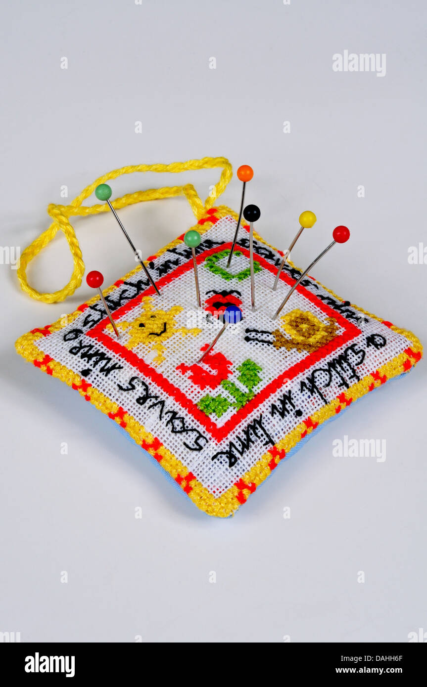 A Stitch in Time salva nove puntaspilli con perni contro uno sfondo semplice. Foto Stock