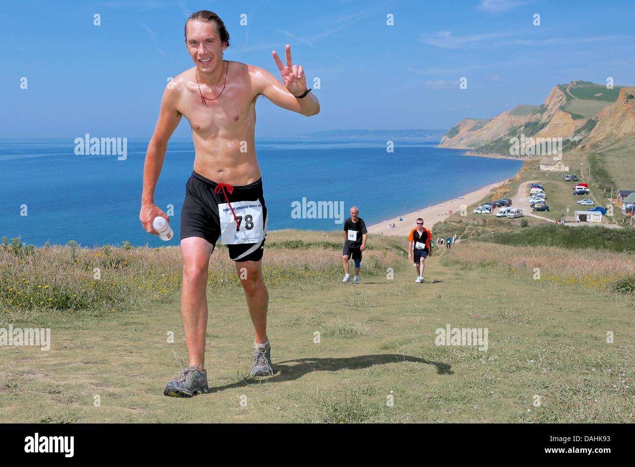 Eype, Dorset, Regno Unito. 14 Luglio, 2013. Corridori che prenderanno parte al Bridport Jurassic Coast eseguire battaglia con sia la temperatura e la morfologia del terreno vicino Eype. Il 10k run è organizzata congiuntamente da Bridport Leisure Centre, Brit Valley Rotary Club e Bridport Guide. Il principalmente off-road eseguire ha preso i partecipanti alla sommità del faro Thorncombe, la seconda più alta collina sulla costa sud. Credito: Tom Corban/Alamy Live News Foto Stock