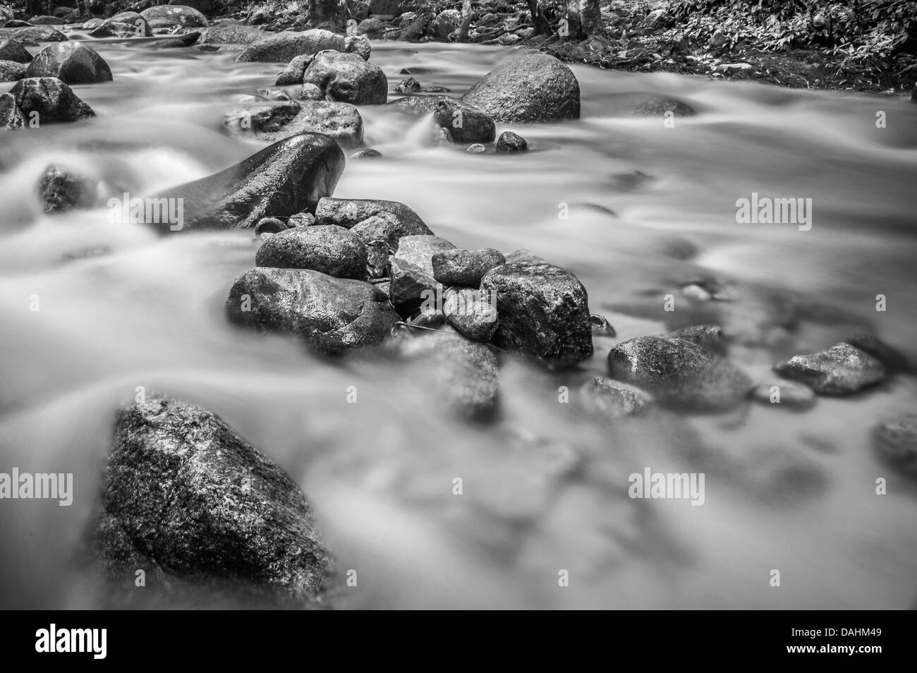 Una lunga esposizione di un fiume che scorre in bianco e nero Foto Stock