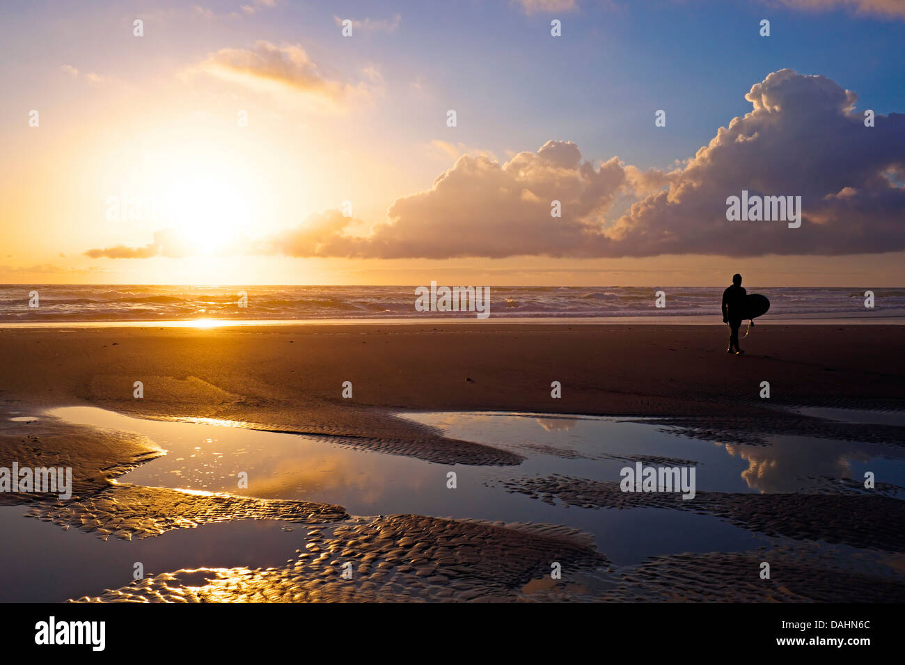 Surfer in spiaggia al tramonto in Portogallo Foto Stock