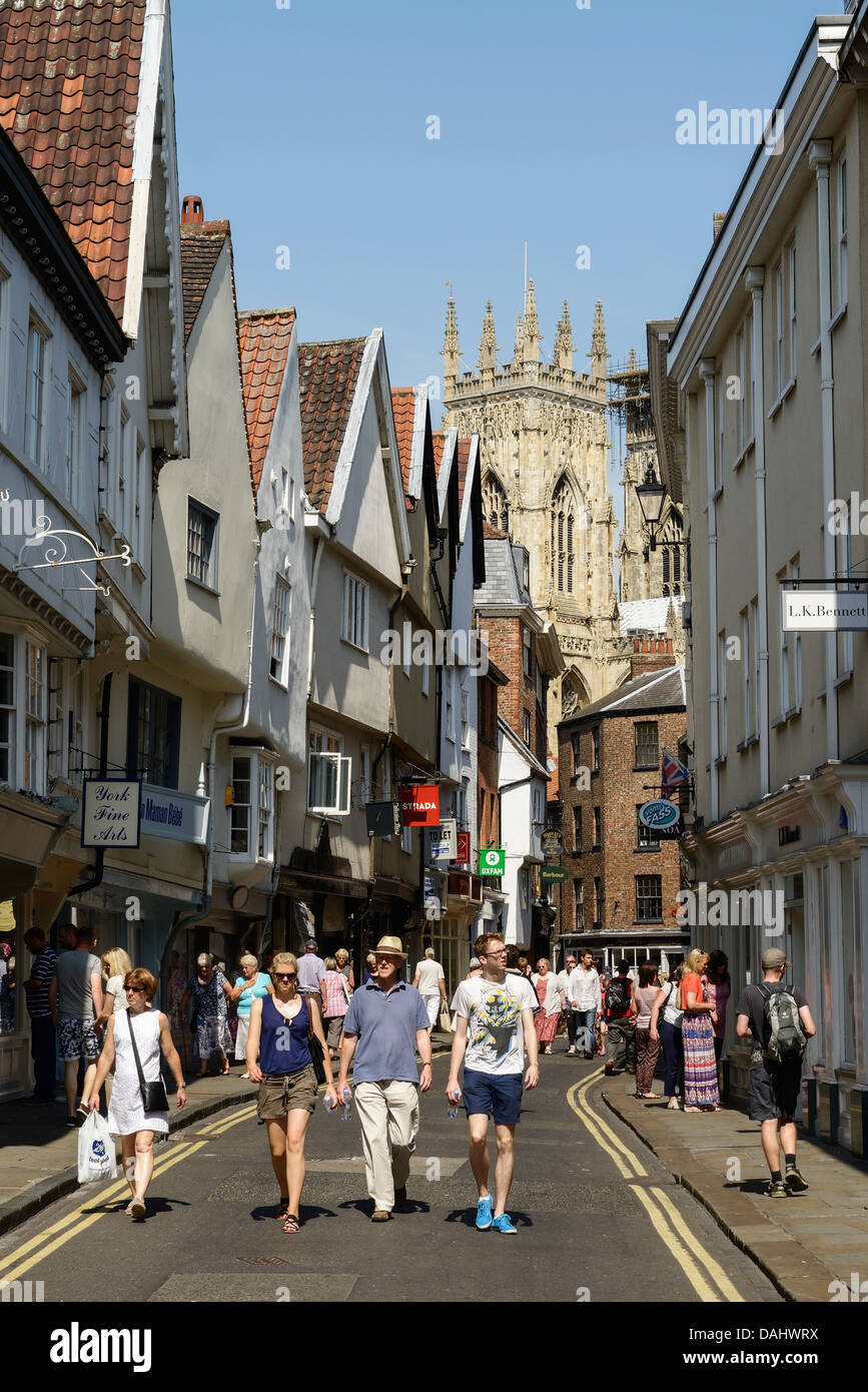 I turisti e gli amanti dello shopping a piedi lungo il basso Petergate vicino a York Cathedral Regno Unito Foto Stock