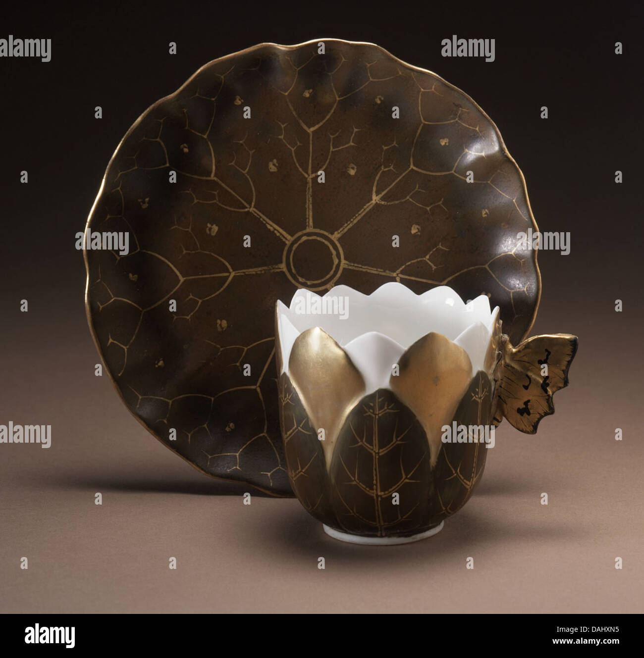 Questa delicata tazza da caffè con ninfee è caratterizzata da un'impugnatura a farfalla dal design sofisticato, che simboleggia l'eleganza dei motivi naturali in ceramica. La lavorazione artigianale della tazza mette in risalto i dettagli artistici ed è un raffinato esempio di porcellana decorativa. Foto Stock