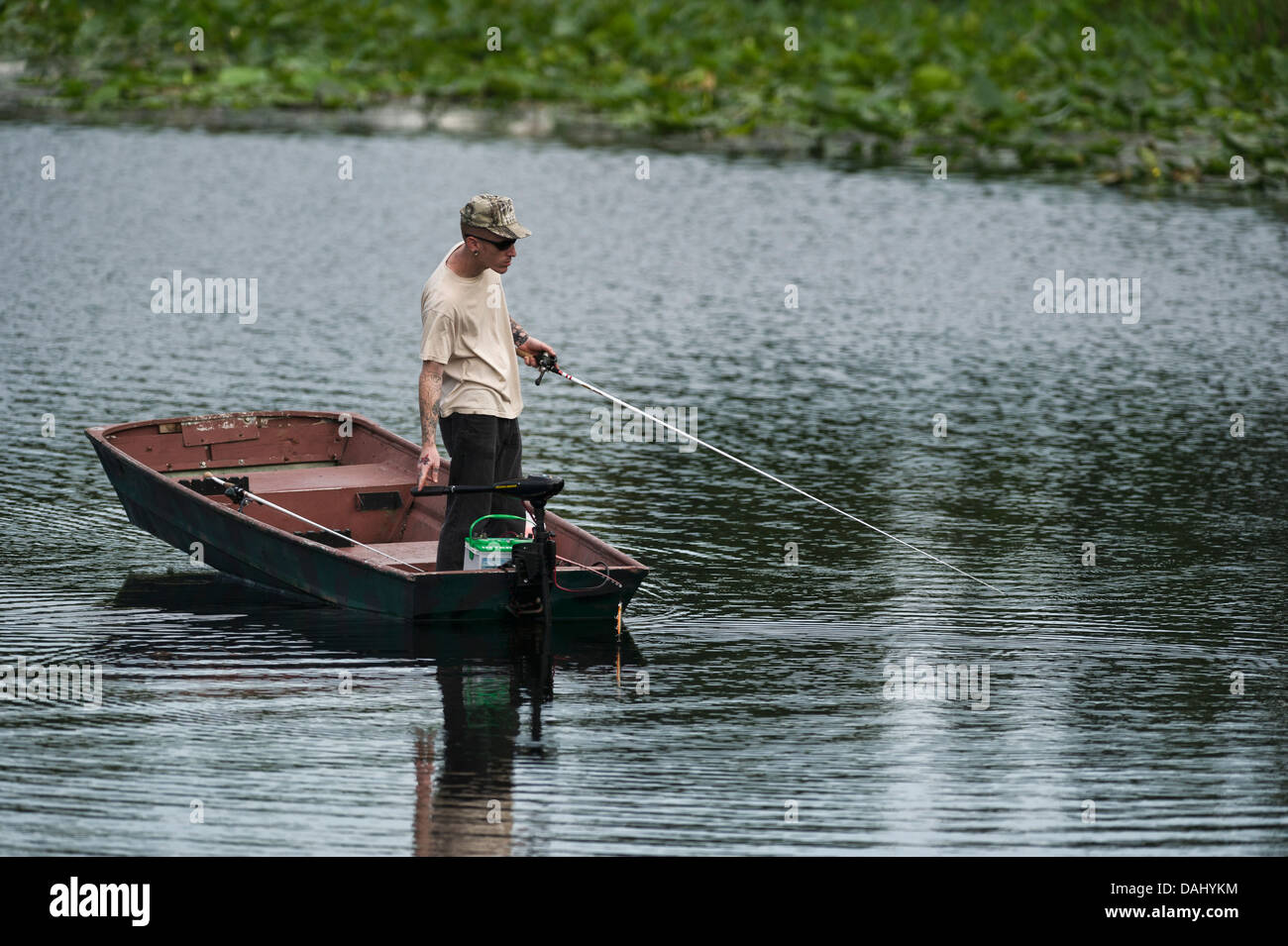 Un sottile uomo in piedi e la pesca da una piccola barca a remi su Haines Creek fiume in Lake County Leesburg, Florida USA Foto Stock
