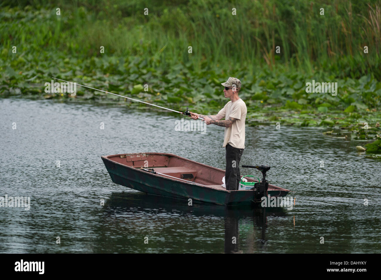 Un sottile uomo in piedi e la pesca da una piccola barca a remi su Haines Creek fiume in Lake County Leesburg, Florida USA Foto Stock